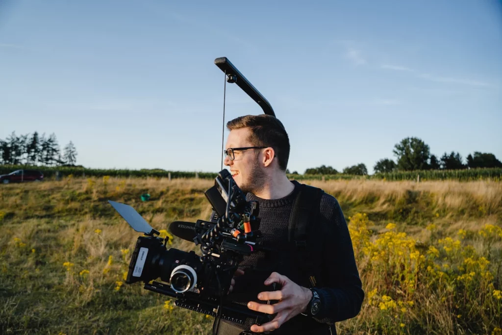 Kameramann bei Drehgut filmt mit professioneller Videokamera im Außeneinsatz